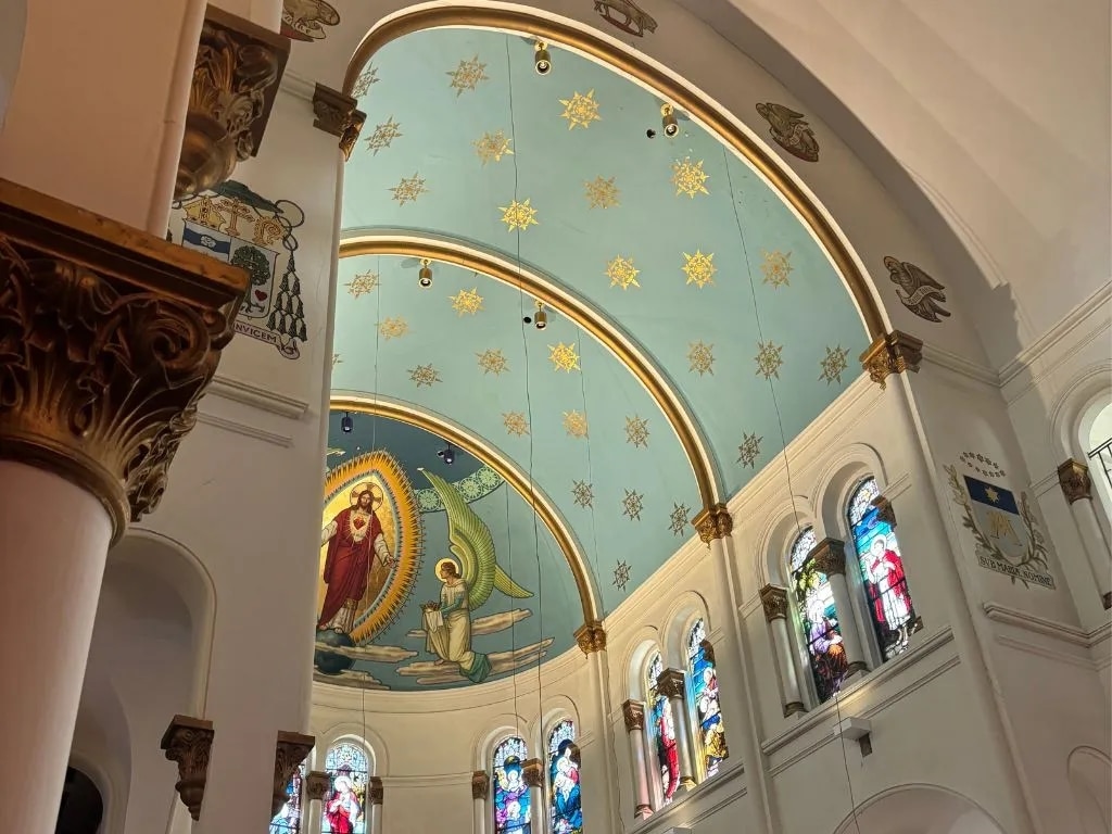 The arched ceiling of a church adorned with art